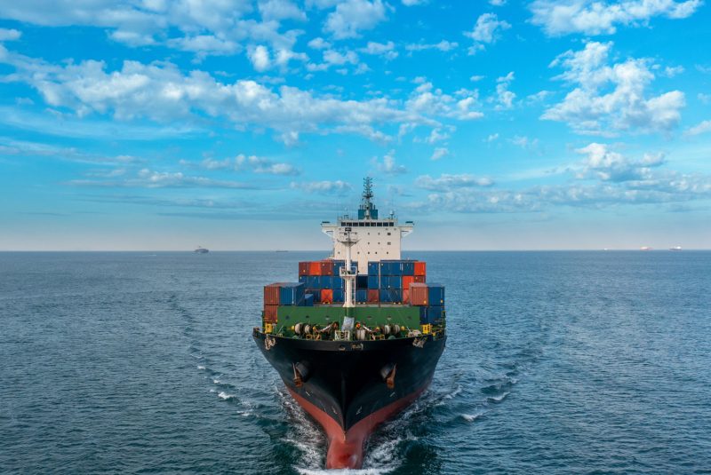 aerial-side-view-of-cargo-ship-carrying-container-2024-12-08-00-51-17-utc